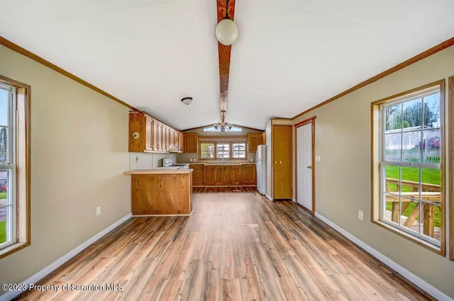 a view of a kitchen with wooden floor and electronic appliances