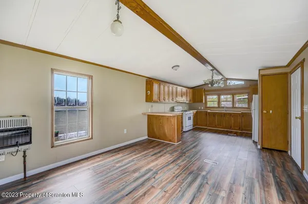 a view of a kitchen with wooden floor and cabinets