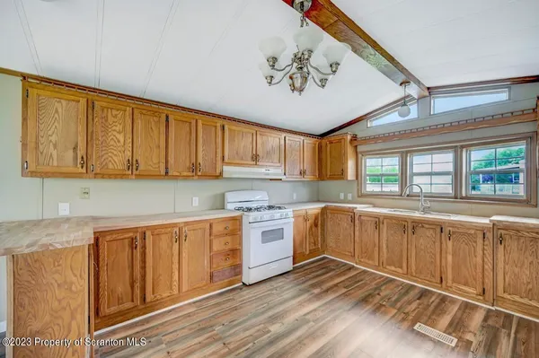 a kitchen with a stove a sink and cabinets