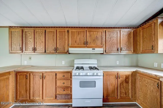 a kitchen with wooden cabinets and a stove top oven