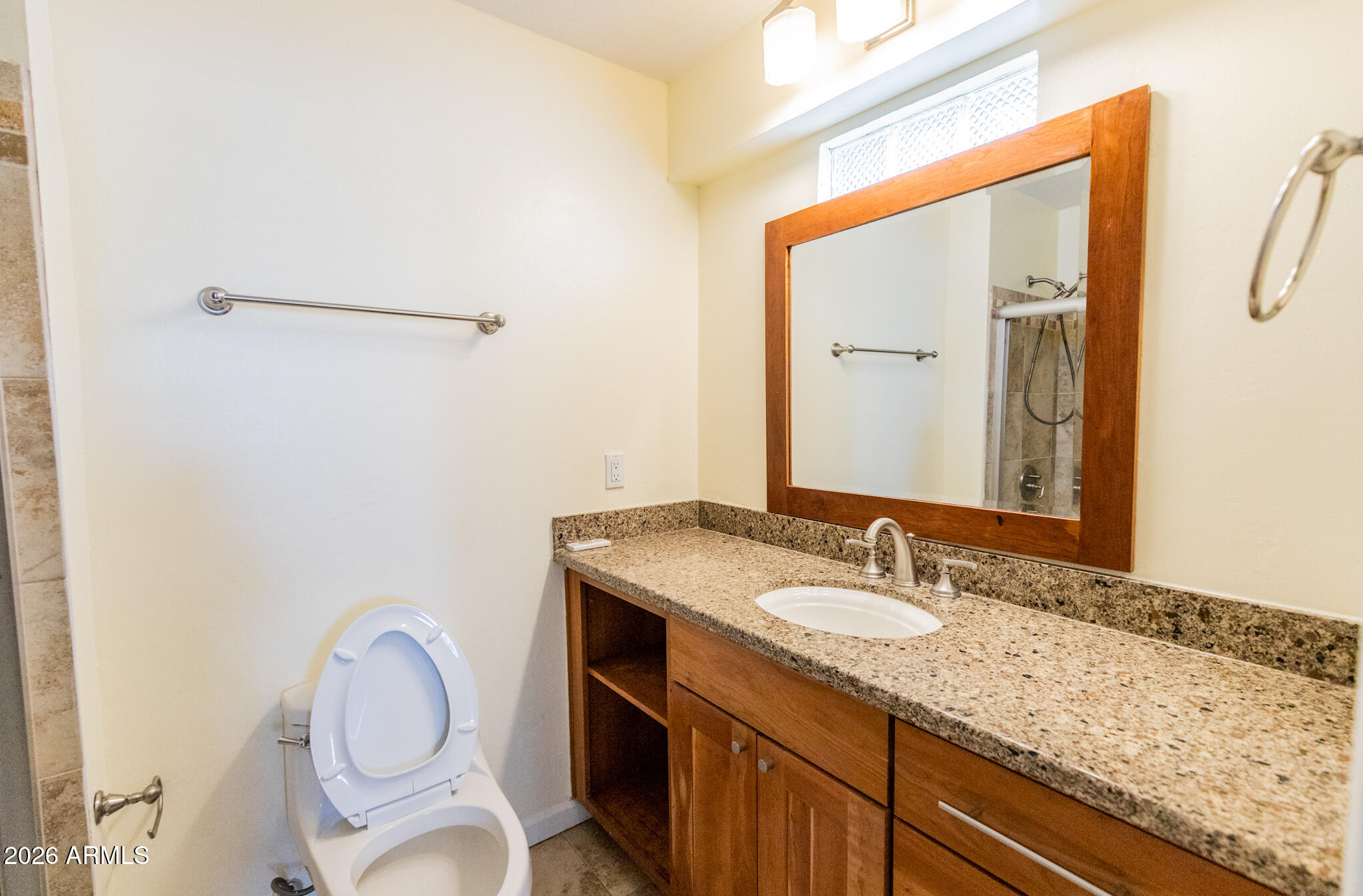 1029 West Elna Rae Street Tempe, AZ 85281 - Photo 11 of 20 a bathroom with a granite countertop sink toilet and a mirror