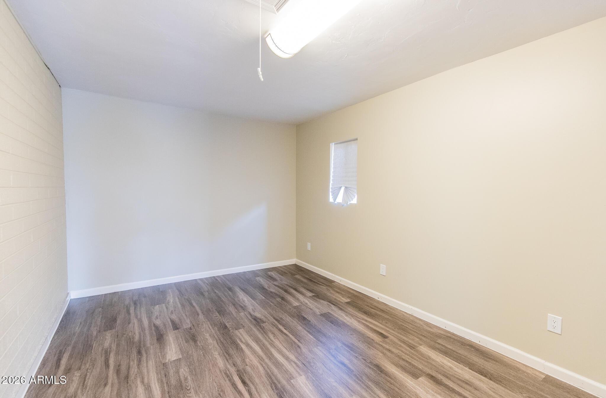 1029 West Elna Rae Street Tempe, AZ 85281 - Photo 17 of 20 a view of an empty room with wooden floor