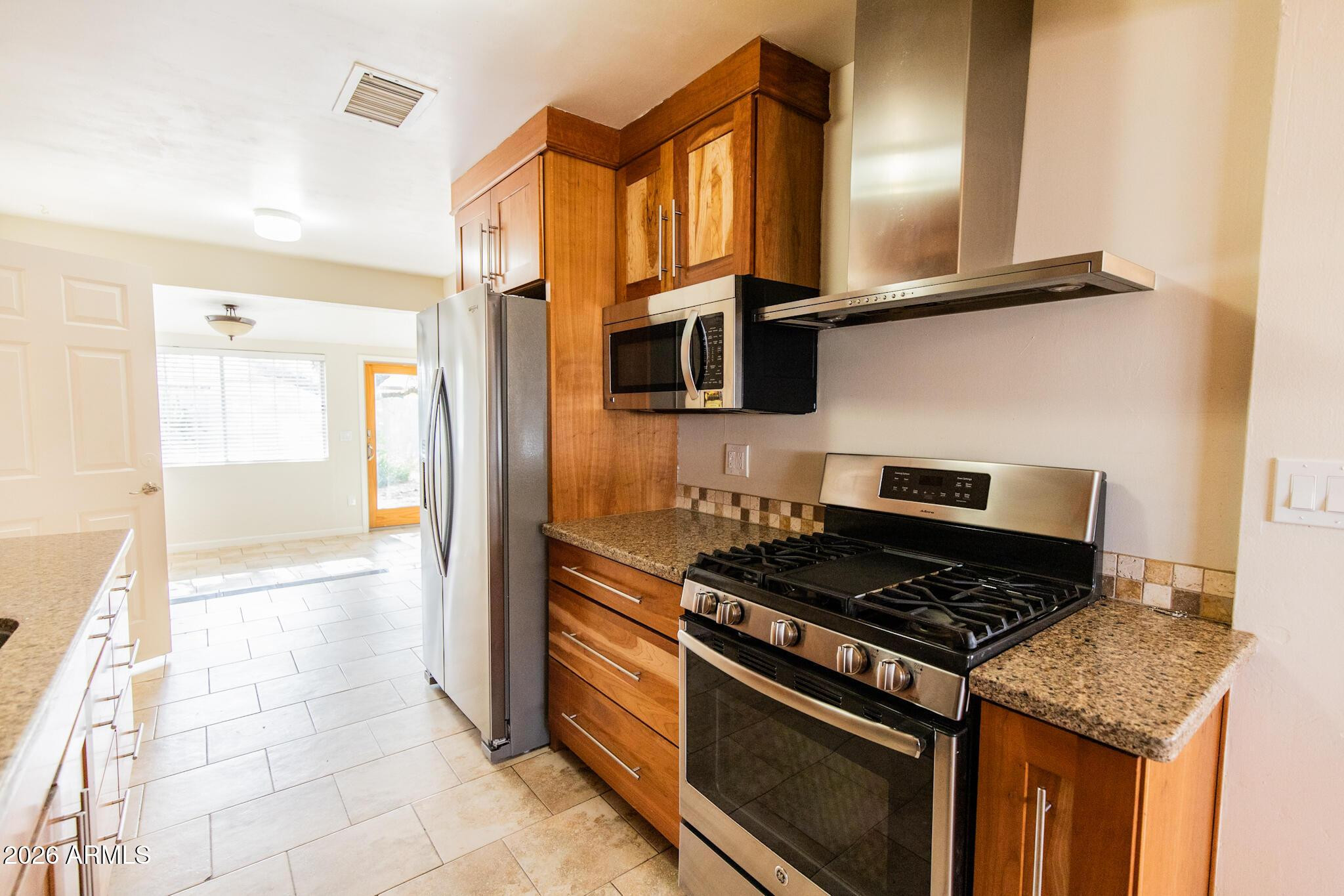 1029 West Elna Rae Street Tempe, AZ 85281 - Photo 5 of 20 a kitchen with stainless steel appliances granite countertop a stove and a refrigerator