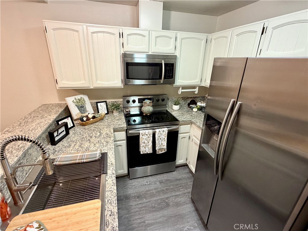 3400 Sullivan Court, Unit 105 Modesto, CA 95356 - Photo 11 of 46 a kitchen with stainless steel appliances granite countertop a stove refrigerator and microwave