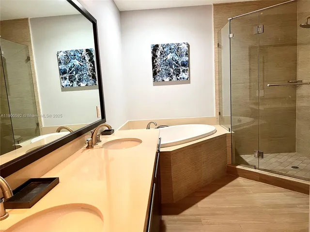 a bathroom with a tub a sink and a shower