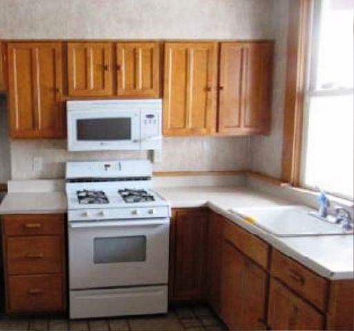 409 Vine Street Homestead, PA 15120 - Photo 5 of 10 a kitchen with a stove and a microwave