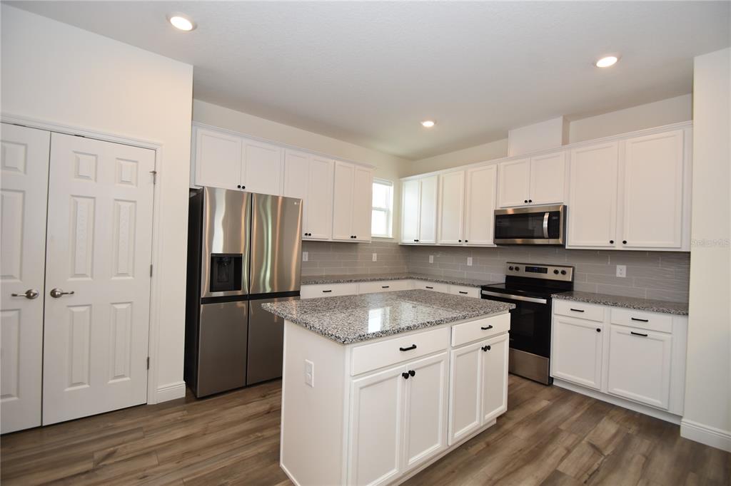 59 Oakleaf Way Palm Coast, FL 32137 - Photo 14 of 39 a kitchen with granite countertop white cabinets and stainless steel appliances