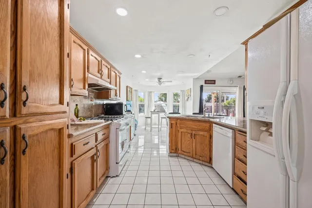 a kitchen with stainless steel appliances granite countertop a refrigerator and a stove top oven