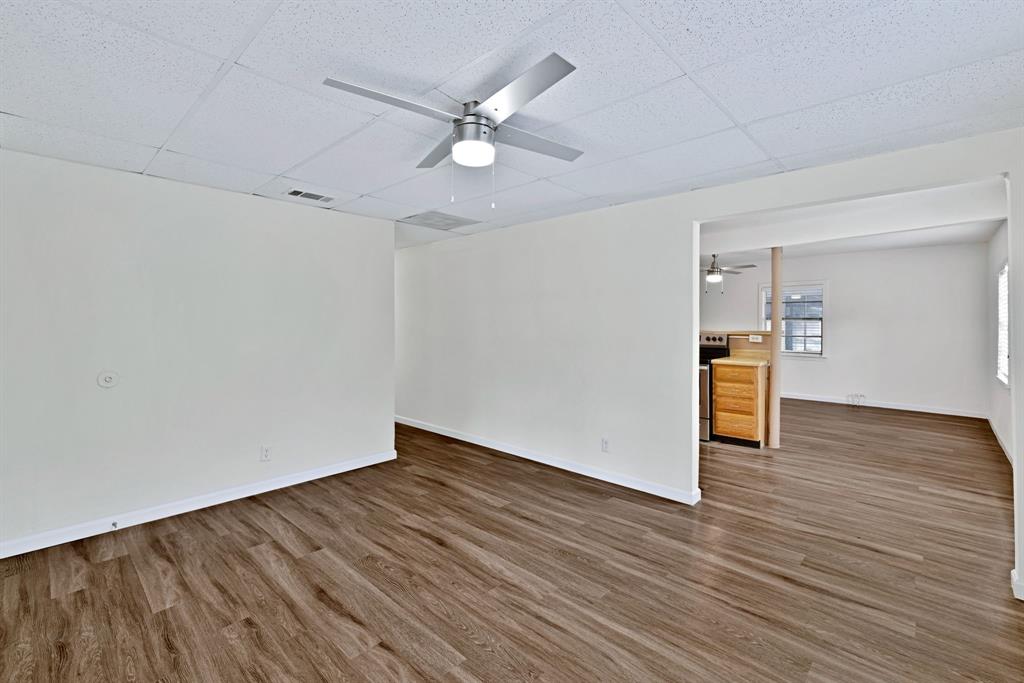 613 Cheyenne Road Dallas, TX 75217 - Photo 5 of 28 Spacious interior room featuring wood-finish flooring, white walls, and a ceiling fan with integrated lighting