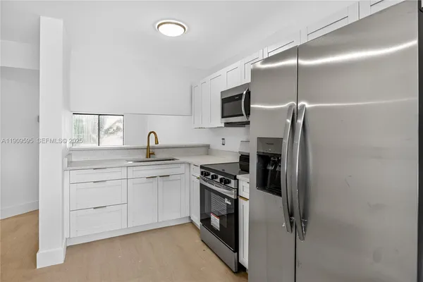 a kitchen with a sink stainless steel appliances and cabinets