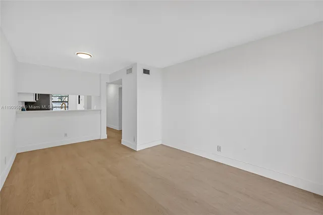 a view of a kitchen with refrigerator and cabinets