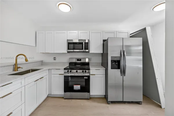 a kitchen with stainless steel appliances granite countertop a refrigerator sink and stove