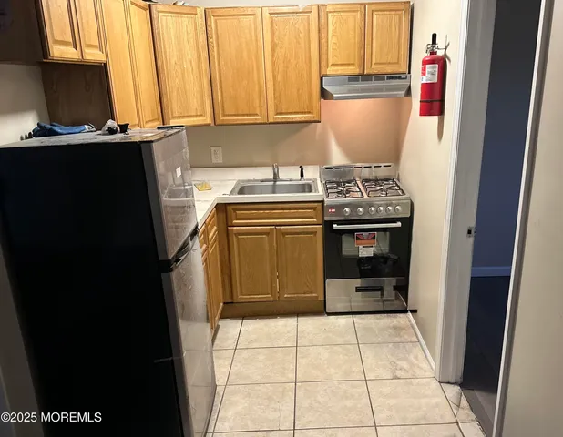 a kitchen with a stove top oven and cabinets