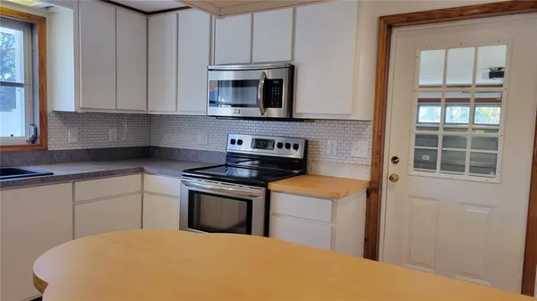 a kitchen with stainless steel appliances granite countertop a stove a sink and a microwave