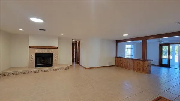 a view of an empty room with a fireplace and window