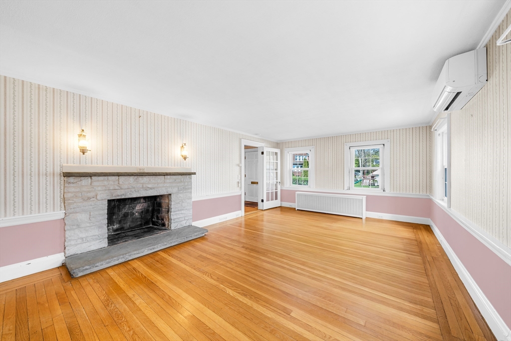 293 Florence Road Waltham, MA 02453 - Photo 16 of 41 a view of empty room with wooden floor and fireplace