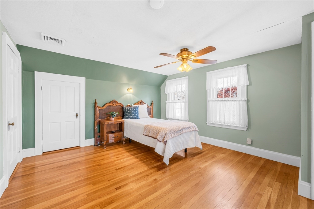 293 Florence Road Waltham, MA 02453 - Photo 22 of 41 a spacious bedroom with a bed and a chandelier
