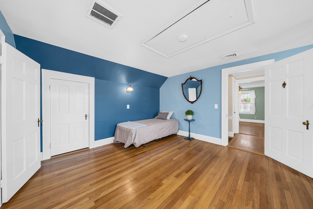 293 Florence Road Waltham, MA 02453 - Photo 27 of 41 a spacious bedroom with a bed and closet with wooden floor