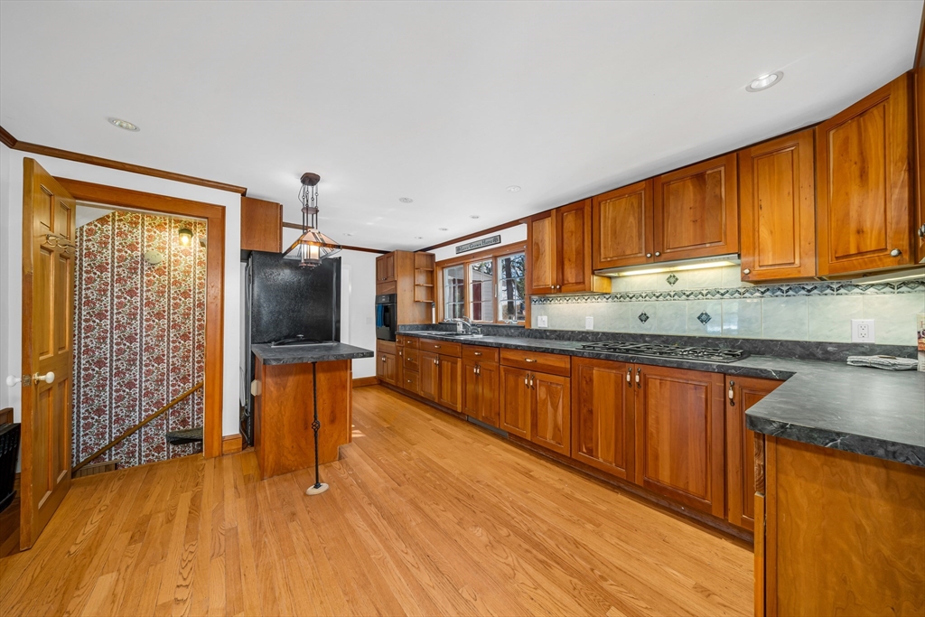 293 Florence Road Waltham, MA 02453 - Photo 6 of 41 a kitchen with stainless steel appliances granite countertop a stove top oven a sink dishwasher a refrigerator and cabinets with wooden floor
