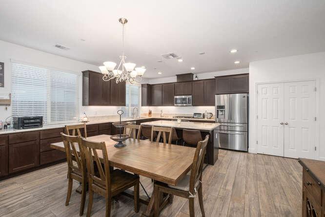 3822 Hannah Lane Clovis, CA 93619 - Photo 13 of 26 a kitchen with a dining table chairs stainless steel appliances and cabinets
