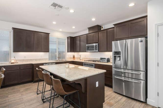 3822 Hannah Lane Clovis, CA 93619 - Photo 9 of 26 a kitchen with kitchen island a refrigerator stove microwave and cabinets