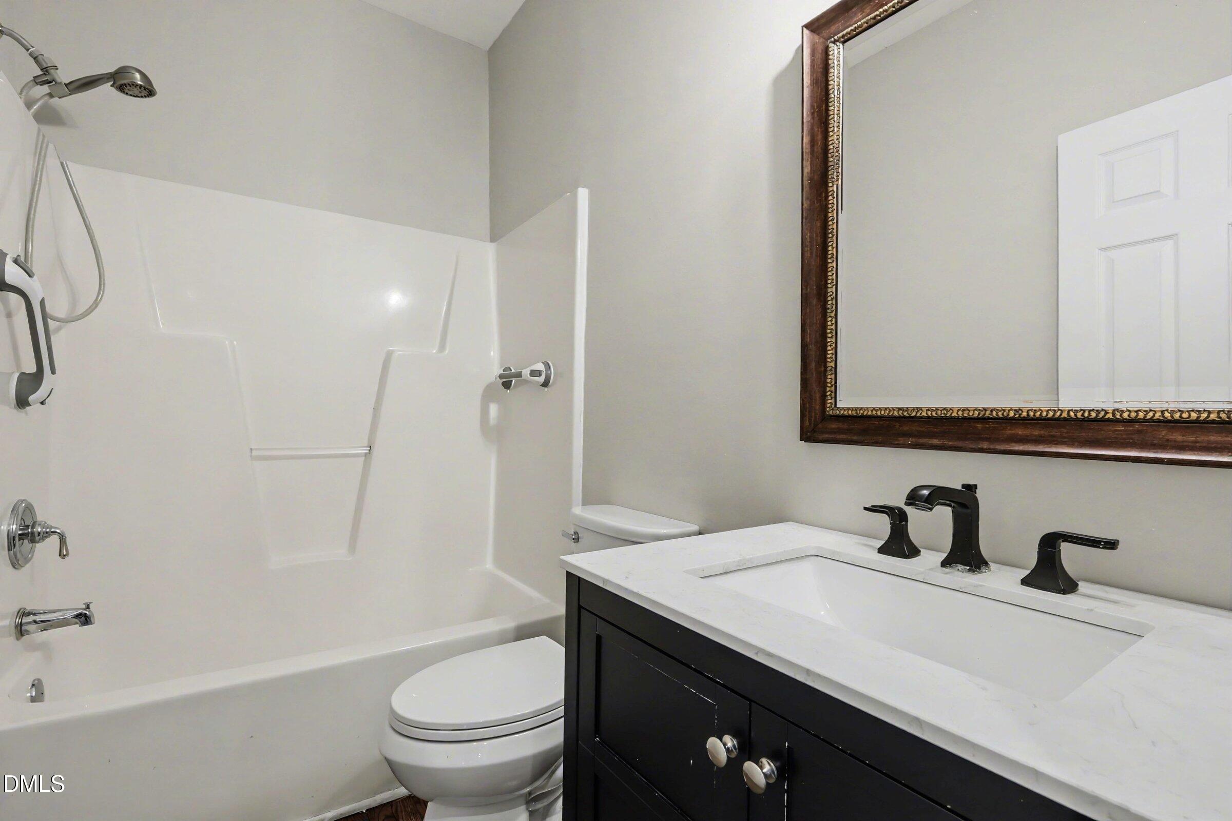 1001 Denfield Court Raleigh, NC 27615 - Photo 29 of 44 a bathroom with a sink a toilet and shower