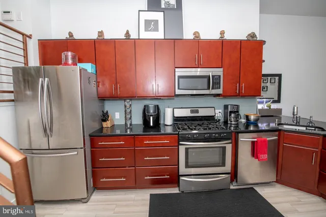 a kitchen with stainless steel appliances granite countertop a refrigerator and a stove top oven