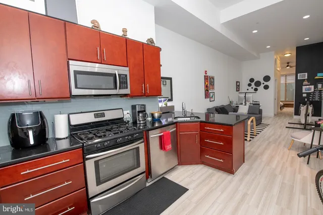 a kitchen with stainless steel appliances granite countertop a stove a sink and a microwave