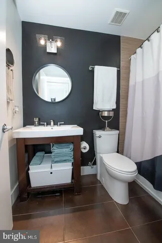 a bathroom with a sink toilet and mirror