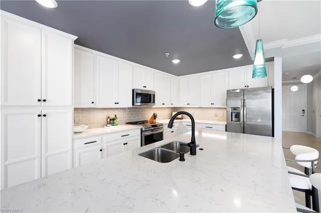 a large kitchen with stainless steel appliances kitchen island a refrigerator sink and cabinets