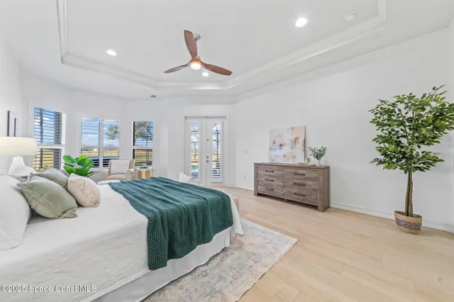 an empty room with wooden floor ceiling fan and windows