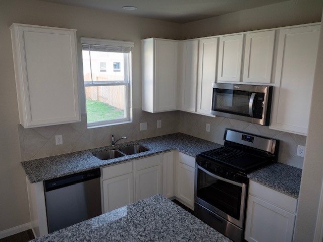 2533 Sturgeon Way Conroe, TX 77384 - Photo 5 of 30 a kitchen with appliances a sink and a stove
