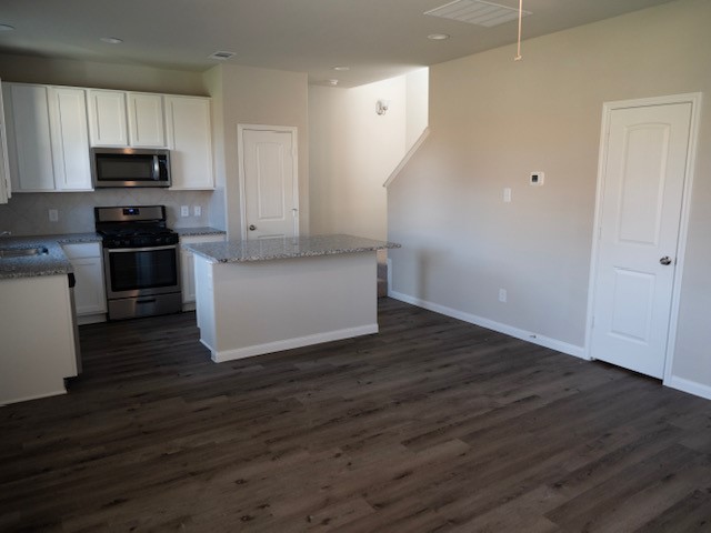 2533 Sturgeon Way Conroe, TX 77384 - Photo 6 of 30 a kitchen with wooden floors and white appliances