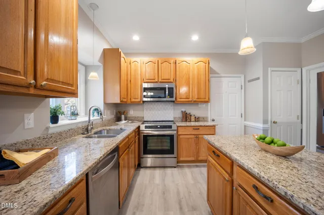 a kitchen with granite countertop a refrigerator a stove and a wooden floors