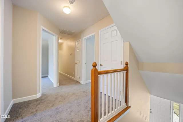 an empty room with a chandelier fan and windows