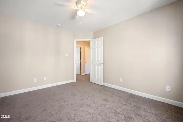 an empty room with closet and windows