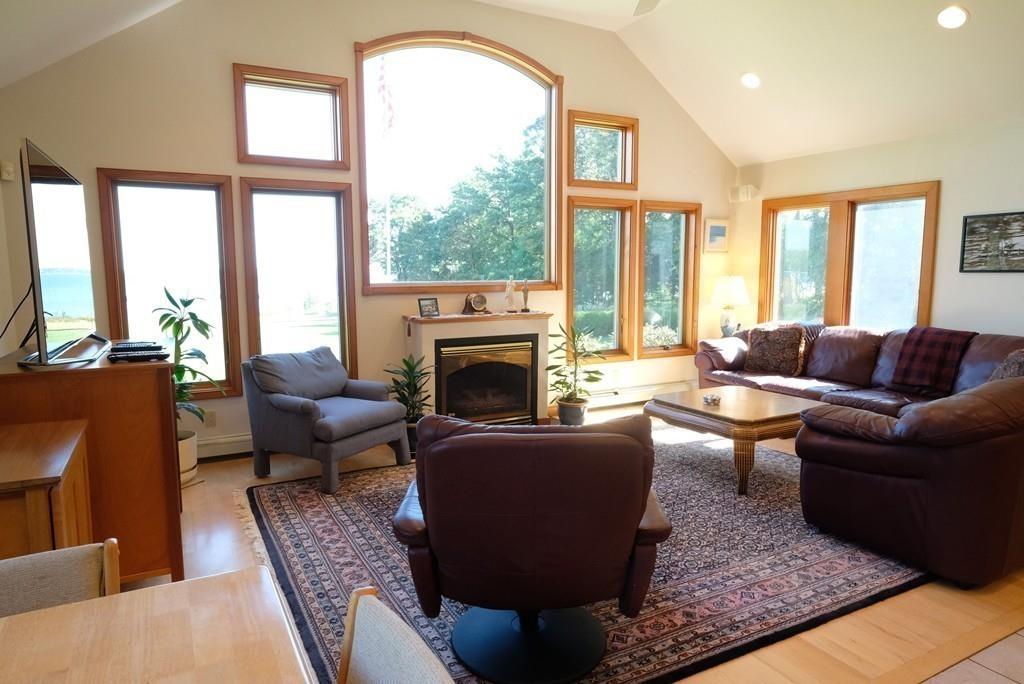 69 Piney Point Road Marion, MA 02738 - Photo 9 of 16 a living room with furniture a large window and a fireplace