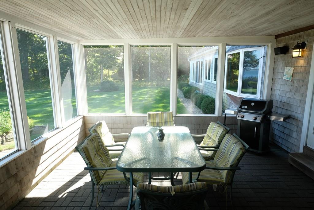 69 Piney Point Road Marion, MA 02738 - Photo 10 of 16 a view of a dining room with furniture large windows and wooden floor