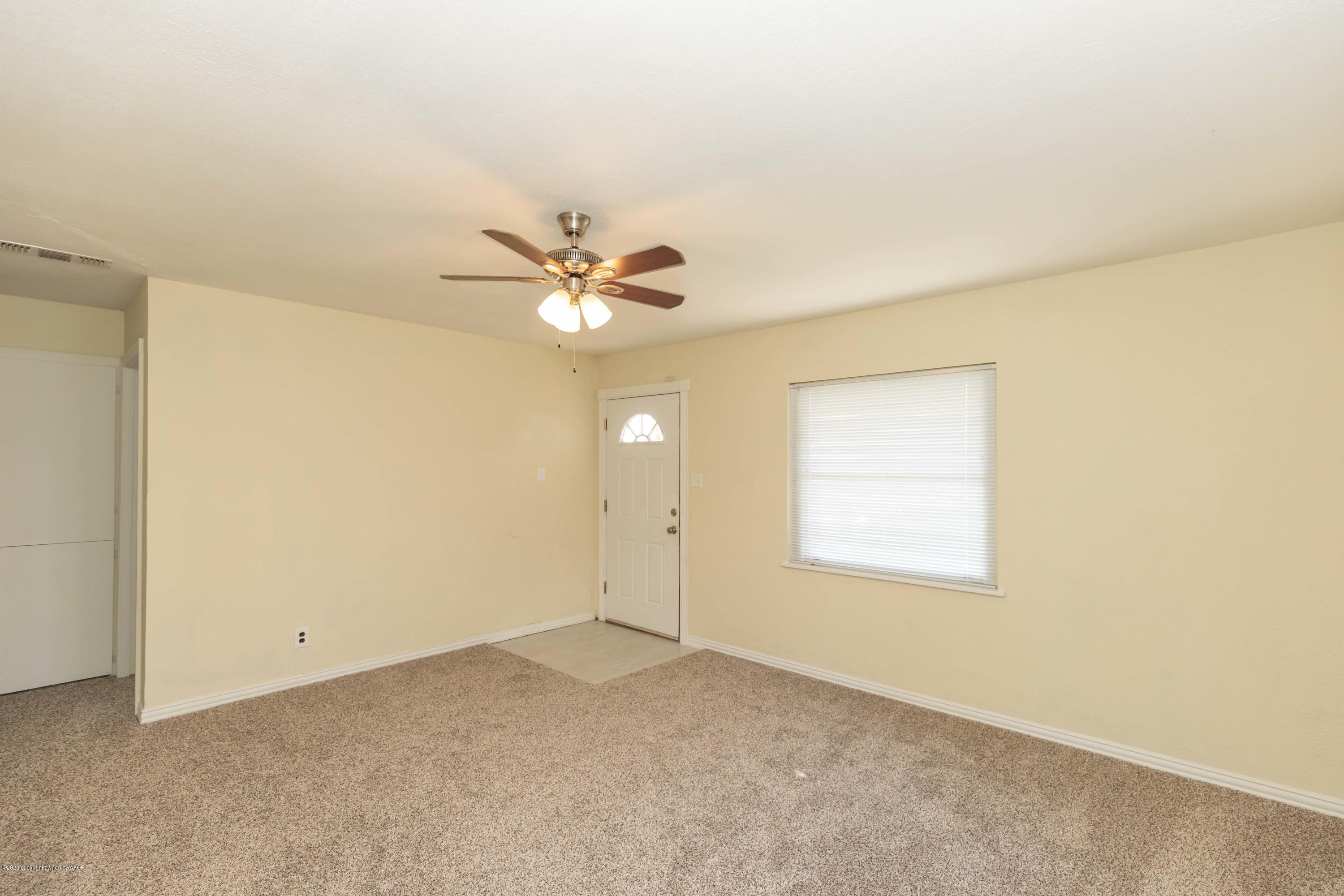 518 Southwest 45th Avenue Amarillo, TX 79110 - Photo 7 of 35 an empty room with a chandelier fan and windows