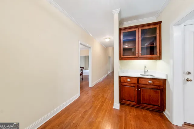 a hallway with sink and wooden floor