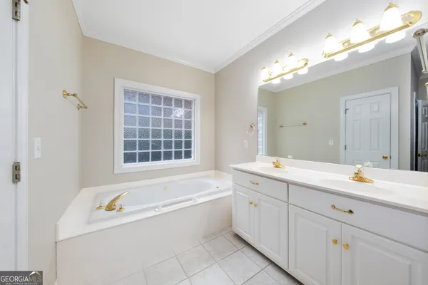 a spacious bathroom with a tub a sink and mirror