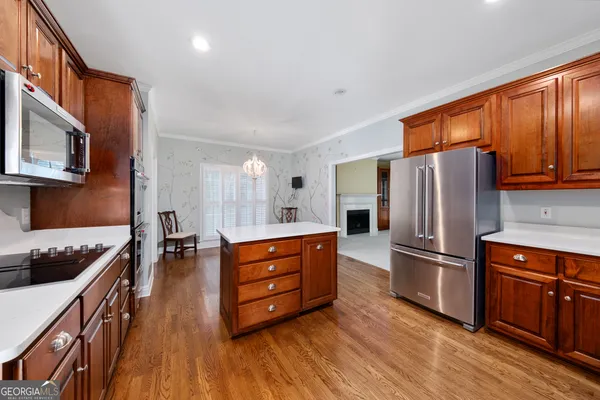 a kitchen with stainless steel appliances a refrigerator and wooden cabinets