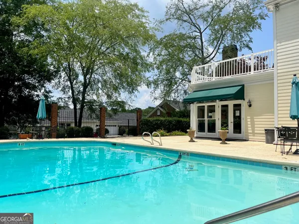 a view of a swimming pool with lawn chairs and plants