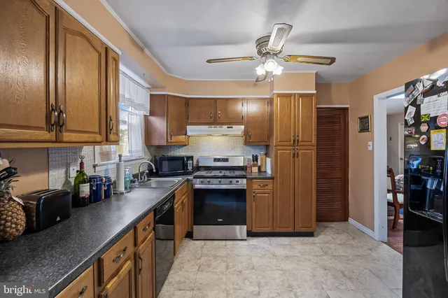 a kitchen with stainless steel appliances granite countertop a stove refrigerator and cabinets