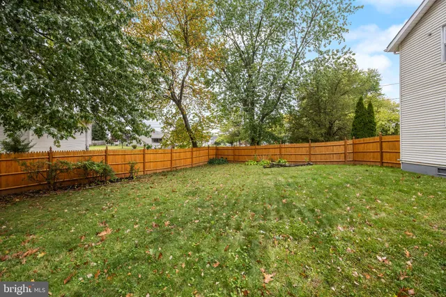 a view of a yard with wooden fence