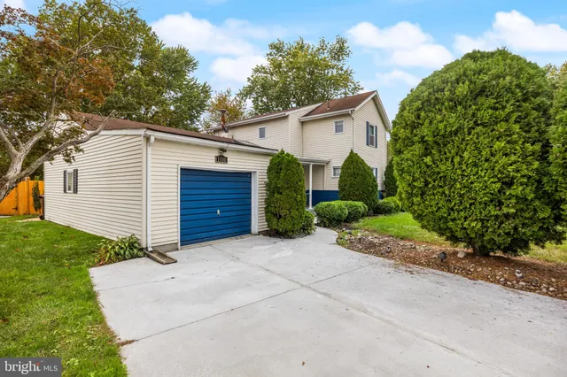 a view of a house with a small yard and a garage