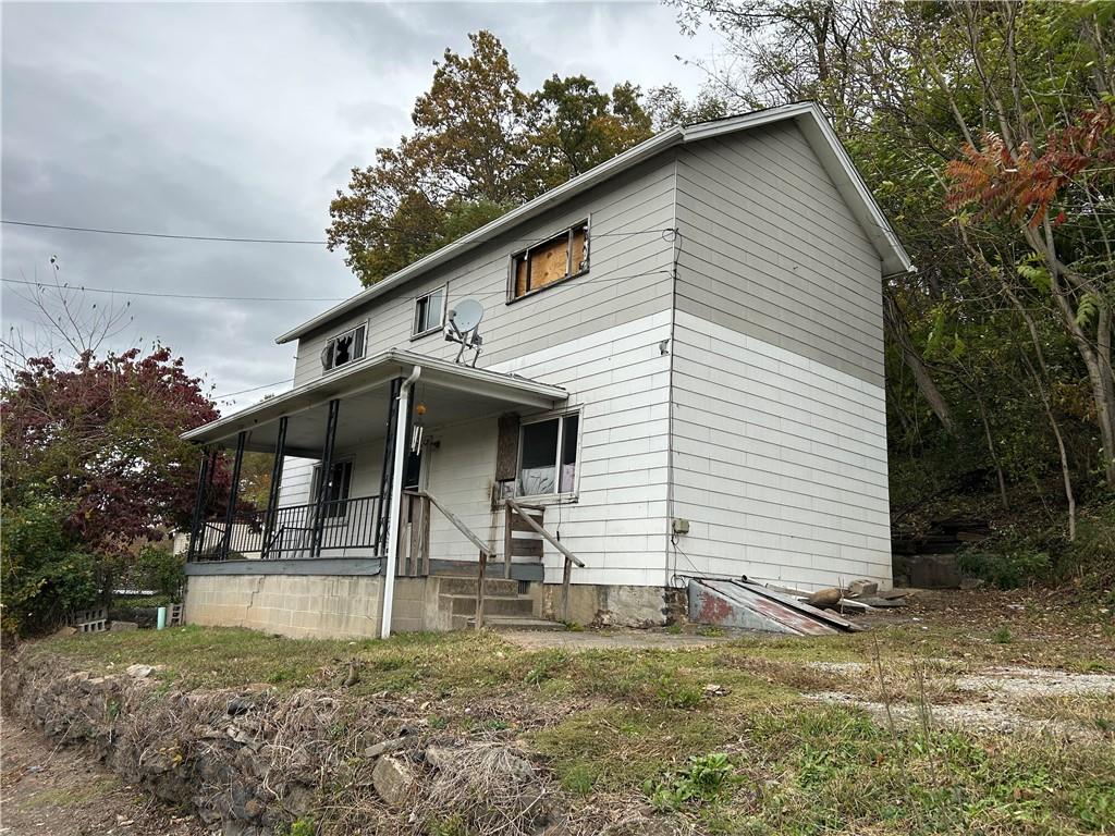 a view of a white house with large windows and a small yard