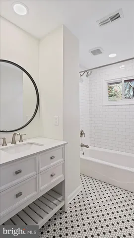 a bathroom with a bathtub sink vanity and a mirror