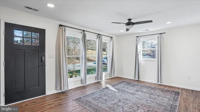 a view of a big room with wooden floor and windows