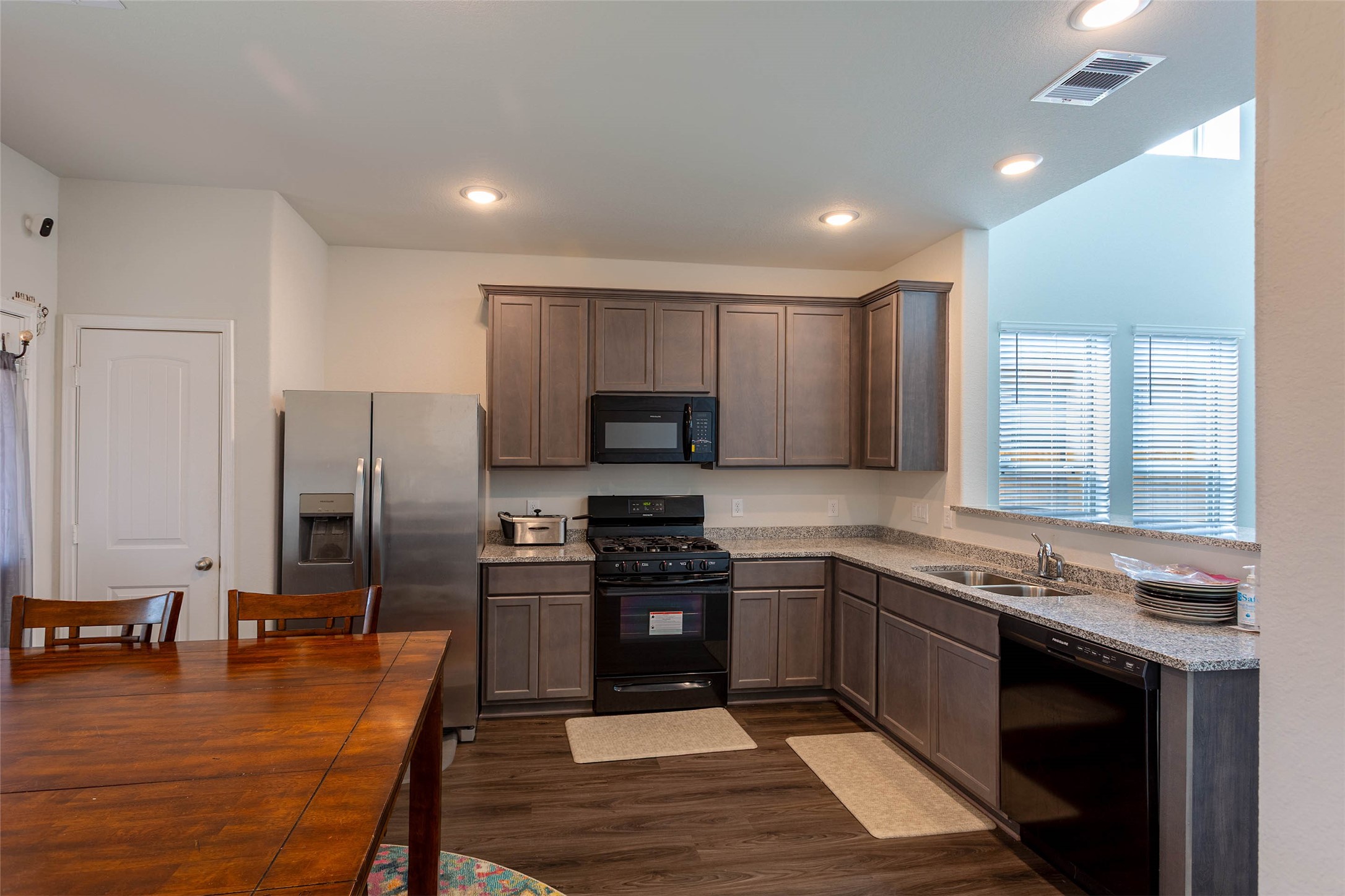14212 Shasta Ridge Drive Conroe, TX 77303 - Photo 6 of 21 a kitchen with stainless steel appliances granite countertop a stove top oven a sink and a refrigerator